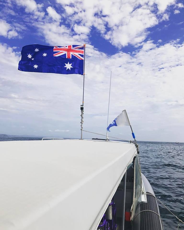Roof of boat showing Australian flag flying next to "divers below" flag